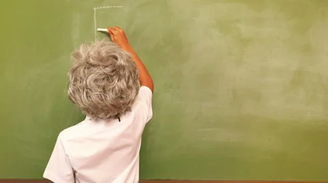 Cute pupil writing maths on chalkboard dressed as Einstein Stock Footage 45382100