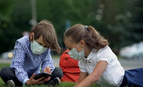 Cute pupils using smartphones at the elementary school. Boy and girl in safety Stock-Fotos