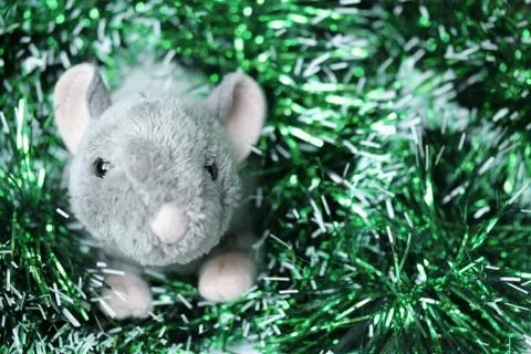 Cute rat or mouse soft toy with green tinsel Stock Photos