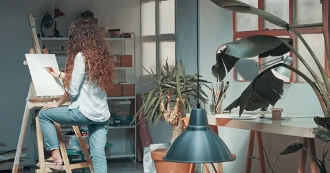 Cute red-haired girl paints in her studio Stock Footage 81086053