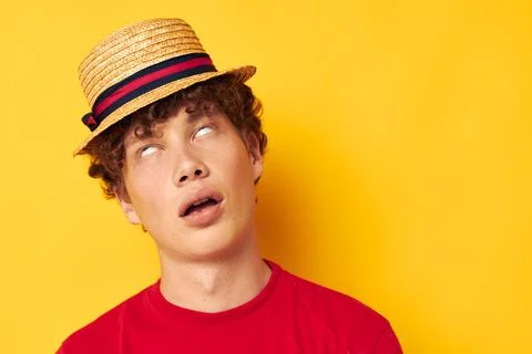Cute red-haired guy emotions red t-shirt hat studio yellow background unaltered Stock Photos