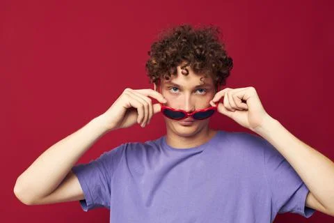Cute red-haired guy hand gestures heart shaped glasses posing red background Stock Photos