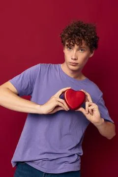 Cute red-haired guy heart in hands gift romance Stock Photos