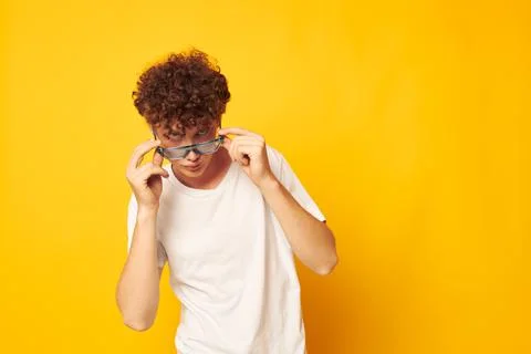 Cute red-haired guy in a white t-shirt blue fashion glasses isolated background Stock Photos