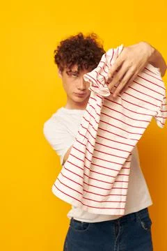 Cute red-haired guy in a white t-shirt holds a striped t-shirt fashion youth Stock Photos