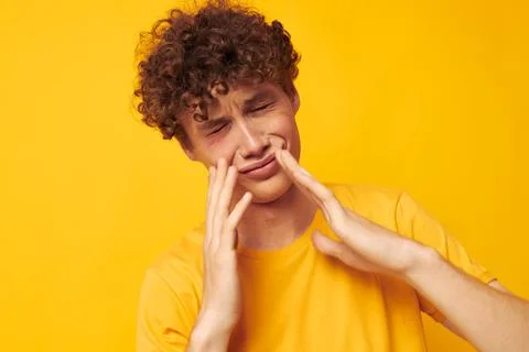 Cute red-haired guy yellow t-shirt fashion hand gestures yellow background Stock Photos