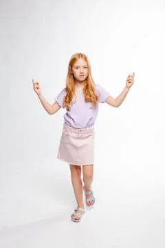 Cute red-haired long-haired girl in daily clothes is angry and raises two han Stock Photos