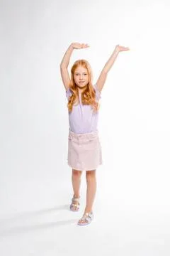 Cute red-haired long-haired girl in daily clothes dancing Stock Photos