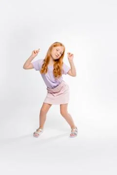 Cute red-haired long-haired girl in daily clothes dancing Stock Photos