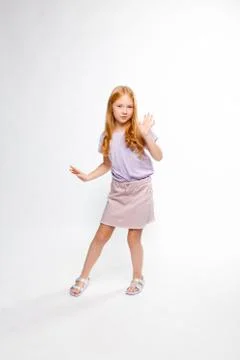 Cute red-haired long-haired girl in daily clothes dancing Stock Photos