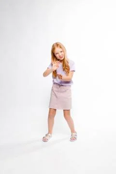 Cute red-haired long-haired girl in daily clothes dancing Stock Photos
