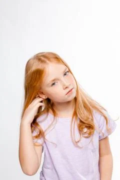 Cute red-haired long-haired girl in daily clothes (skirt, T-shirt) straighten Stock Photos