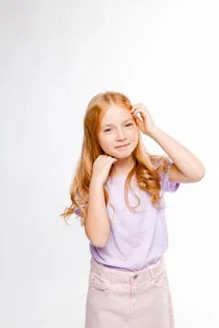 Cute red-haired long-haired girl in daily clothes (skirt, t-shirt) Stock Photos