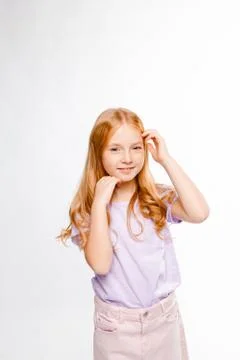 Cute red-haired long-haired girl in daily clothes (skirt, t-shirt) Stock Photos