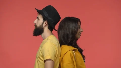 Cute romantic multi-ethnic couple, man and woman standing back to back, turn Stock Footage 115780450