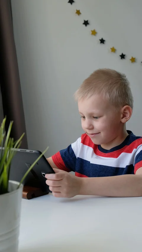 Cute school boy learning or playing on computer tablet pc, distance education Stock Footage 128976507