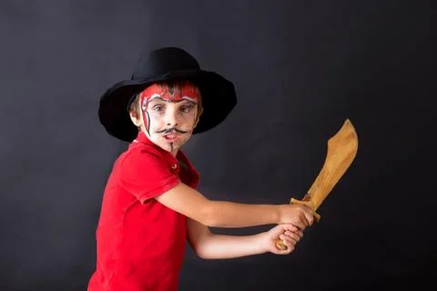 Cute school boy, playing games, painted as pirate, holding sword Stock Photos