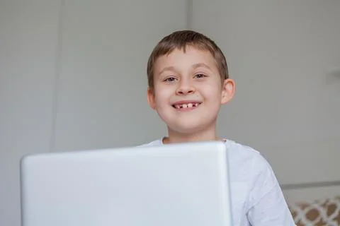 Cute schoolboy doing homework on the bed. A little boy of 7 years old is doin Stock Photos