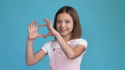Cute schoolchild make hands romance heart isolated blue color background Stock Footage 167261825
