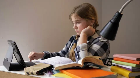 Cute schoolgirl communicates with classmates using a laptop. Online learning. Stock Footage 128378423