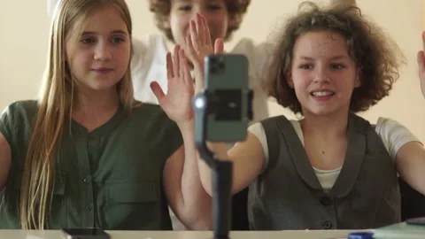 Cute schoolgirls and schoolboy record video on a smartphone camera. Teenagers Stock Footage 167590341