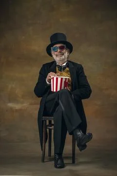 Cute senior smiling man, gentleman, aristocrat or actor watching movie isolated Stock Photos