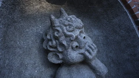 Cute shaded stone cherub devil statue hyper lapse lit by morning sunlight Video stock 263895983