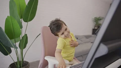 Cute singing little kid dancing in front of desktop computer laptop at home Stock Footage 246098961