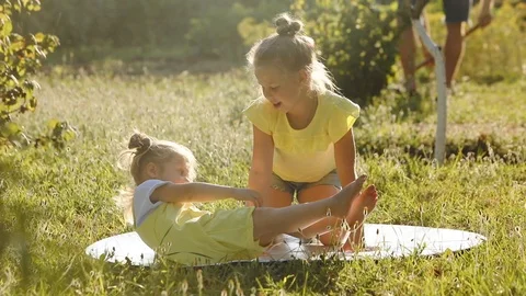 Cute sisters spend time in summer garden on sunny day Stock Footage 113678221
