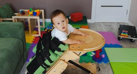 Cute small boy with coordination disorders uses supportive equipment to assis Stock Photos