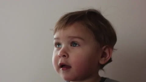 Cute small boy interested watching TV cartoons in the kitchen on a sunny day 스톡 동영상 123072938