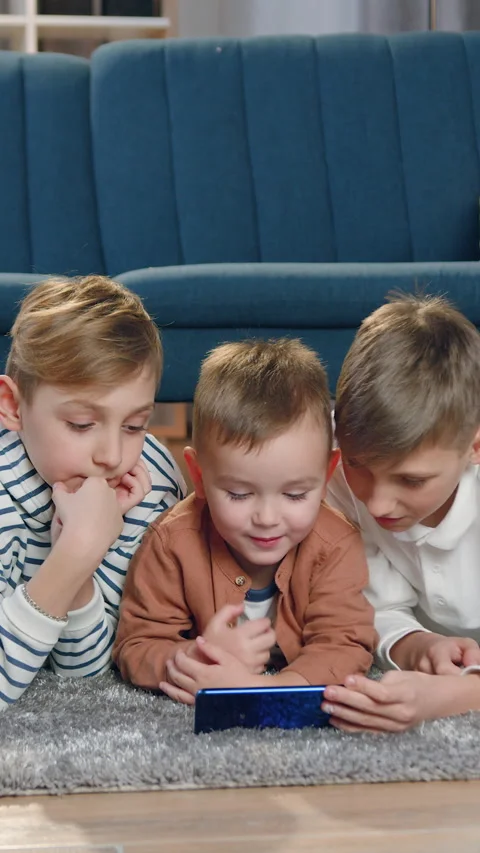 Cute small boy revisioning interesting programm or play game on mobile together  Video stock 328729944