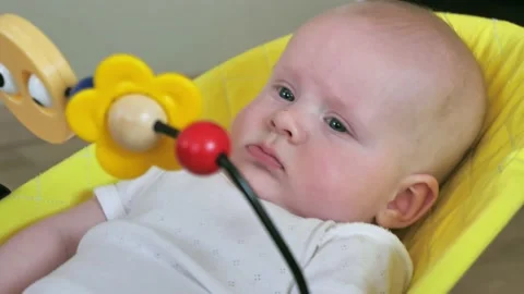 Cute small child face closeup, baby boy lying in rocking chair for kids. Slow Video stock 234309593