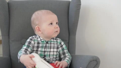 Cute Small kid in a shirt sitting in a baby chair. Stock Footage 149142660