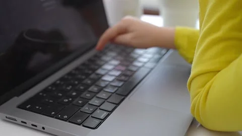 Cute smart caucasian primary School Child typing on the keyboard laptop. Online Stock Footage 233463371