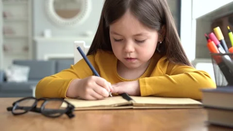 Cute smart primary school child girl learning writing doing homework Stock Footage 131431613
