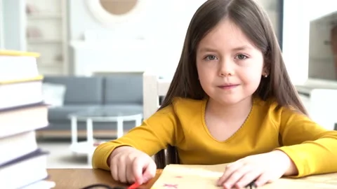 Cute smart primary school child girl learning writing doing homework Stock Footage 131431614