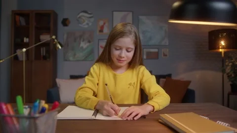 Cute smart primary school child girl learning writing doing math homework sit at Stock Footage 150436307