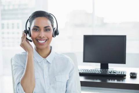 Cute smiling agent wearing headset looking at camera Stock Photos