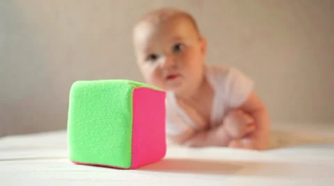 Cute smiling baby crawling to a toy cube for the camera Stock Footage
