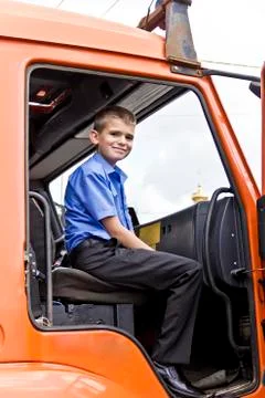 Cute smiling boy sitting in fire engine Stock Photos
