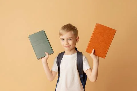 Cute smiling child with a backpack holding books in preparation for school Stock Photos