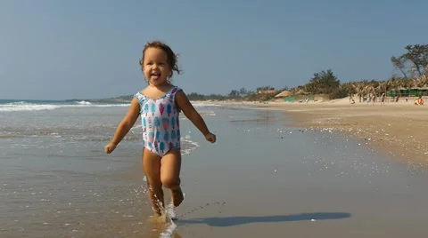 Cute smiling child having fun on the seashore, splashing in sea. Slow motion Stock-Footage 50606074