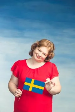Cute smiling chubby red-haired woman holding a swedish flag Stock Photos
