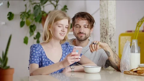 Cute smiling female enjoying using smart device with affectionate Hispanic male Stock Footage 108797128