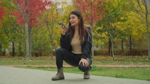Cute smiling Girl Using Smartphone in the park Red Helium 8K Stock-Footage 142652178