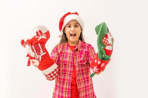Cute smiling toddler girl in a red dress checking her Christmas stocking Stock Photos