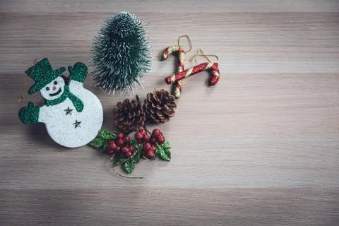 Cute snowman, tiny pine tree, pinecones, glitter holly berries arrange on woo Stock Photos