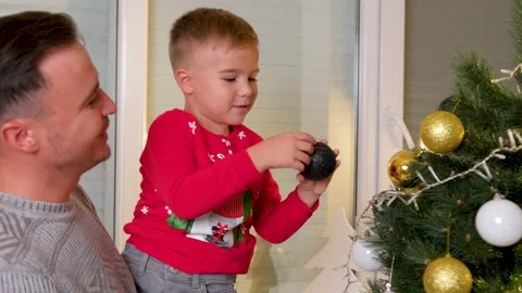 Cute son decorating the christmas tree with his father in the living room Stock Footage 167173666