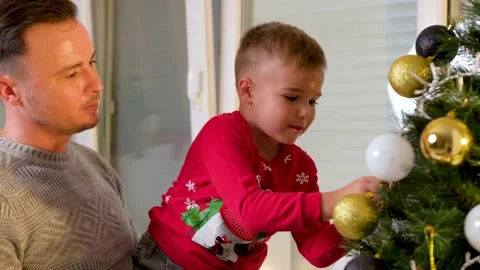 Cute son decorating the christmas tree with his father in the living room Stock Footage 222578264